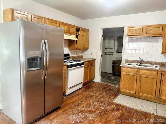 419 Minor St, Tahlequah, OK 74464 - kitchen featuring stainless steel fridge with ice dispenser, white range with gas cooktop, a sink, under cabinet range hood, and decorative backsplash
