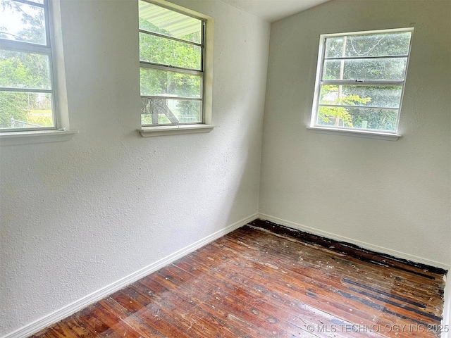 419 Minor St, Tahlequah, OK 74464 - unfurnished room with hardwood / wood-style floors, baseboards, healthy amount of natural light, and a textured wall
