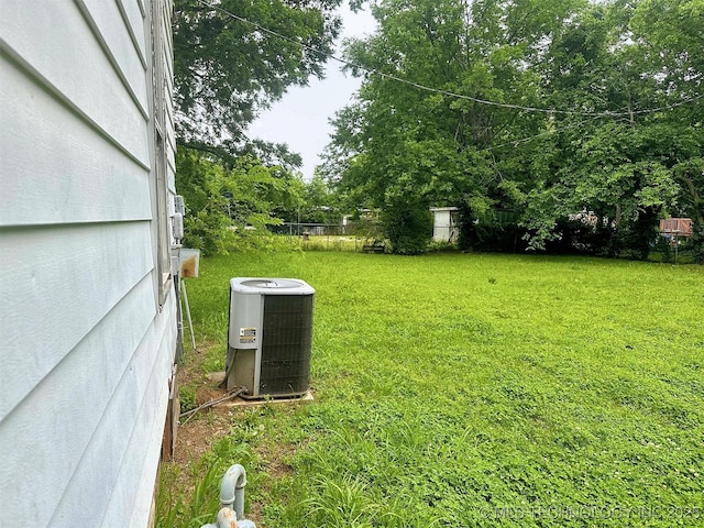 419 Minor St, Tahlequah, OK 74464 - view of grassy yard featuring central air condition unit and view of wooded area