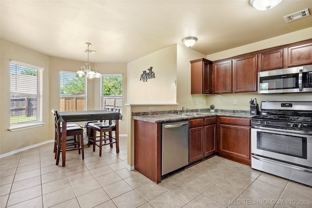 20225 E 44th St S, Broken Arrow, OK 74014 - kitchen featuring stainless steel appliances, a chandelier, dark countertops, light tile patterned floors, and a peninsula