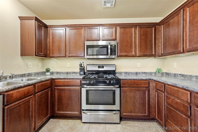 20225 E 44th St S, Broken Arrow, OK 74014 - kitchen featuring stainless steel appliances, a sink, light tile patterned floors, and dark countertops