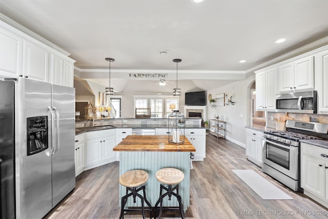 5720 E 144th St N, Collinsville, OK 74021 - kitchen featuring stainless steel appliances, wood counters, a sink, a peninsula, and decorative backsplash
