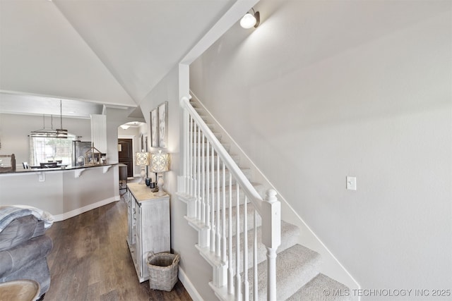 5720 E 144th St N, Collinsville, OK 74021 - staircase featuring lofted ceiling, wood finished floors, arched walkways, and baseboards