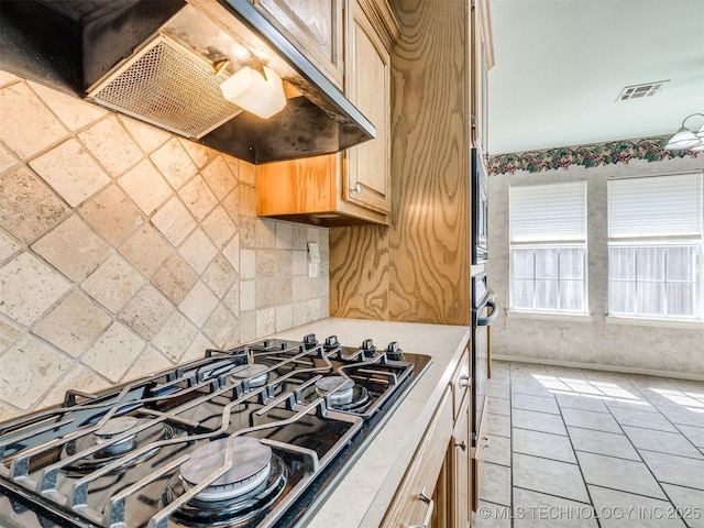 4708 W Indianola St, Broken Arrow, OK 74012 - kitchen with under cabinet range hood, black gas cooktop, light countertops, light brown cabinetry, and light tile patterned floors