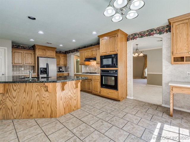 4708 W Indianola St, Broken Arrow, OK 74012 - kitchen with black appliances, a chandelier, decorative backsplash, dark stone counters, and a sink
