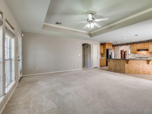 4708 W Indianola St, Broken Arrow, OK 74012 - unfurnished living room with light colored carpet, ceiling fan, a tray ceiling, healthy amount of natural light, and crown molding