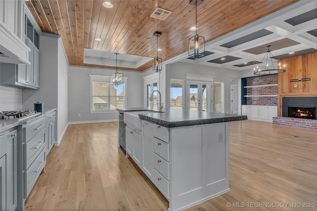 4922 S 81st W Ave, Tulsa, OK 74107 - kitchen with a sink, a chandelier, light wood-style flooring, dark countertops, and baseboards