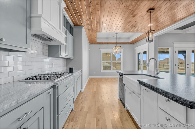 4922 S 81st W Ave, Tulsa, OK 74107 - kitchen featuring a chandelier, custom exhaust hood, wood ceiling, a tray ceiling, and stainless steel appliances