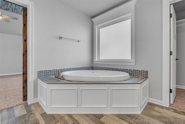 4922 S 81st W Ave, Tulsa, OK 74107 - bathroom featuring a bath, wood finished floors, a ceiling fan, and baseboards