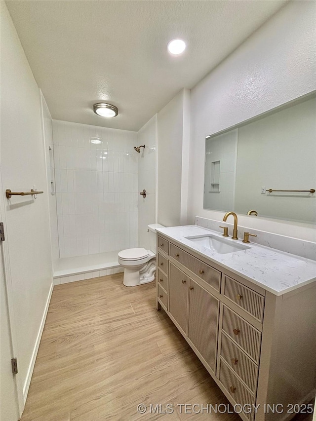 1903 Swan Ln, Mcalester, OK 74501 - full bathroom with toilet, wood finished floors, tiled shower, and vanity