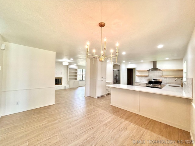 1903 Swan Ln, Mcalester, OK 74501 - kitchen featuring stainless steel appliances, a sink, wall chimney exhaust hood, open floor plan, and a chandelier