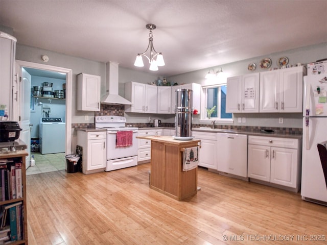 5404 Ranch Rd, Kingston, OK 73439 - kitchen with white appliances, wall chimney exhaust hood, washer / clothes dryer, a chandelier, and a kitchen island