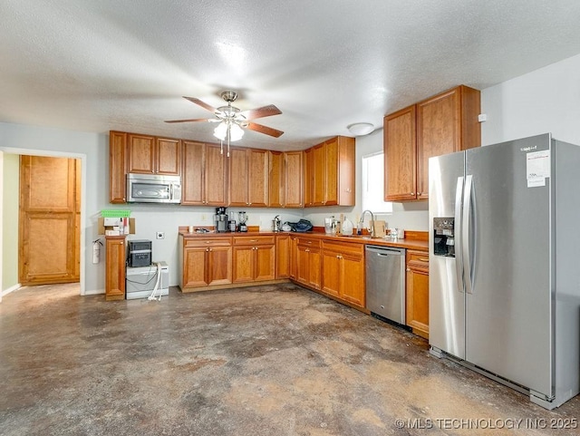 1533 County Road 3480, Ada, OK 74820 - kitchen with appliances with stainless steel finishes, a sink, concrete floors, ceiling fan, and brown cabinetry