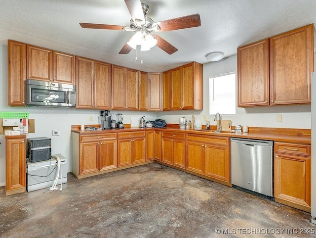 1533 County Road 3480, Ada, OK 74820 - kitchen with stainless steel appliances, a sink, ceiling fan, and brown cabinetry