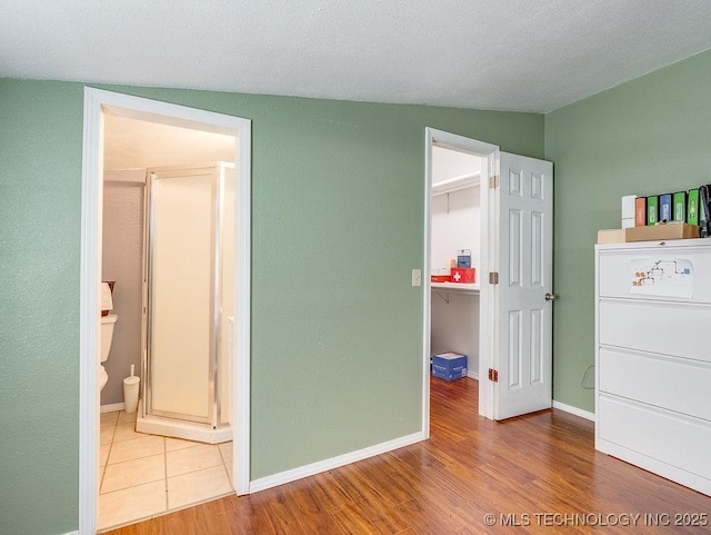 1533 County Road 3480, Ada, OK 74820 - unfurnished bedroom with a spacious closet, wood finished floors, a closet, baseboards, and ensuite bathroom