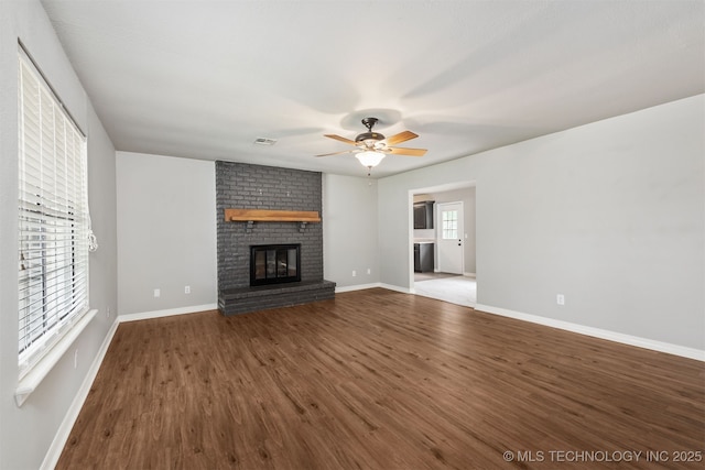 202 NE B St NE, Inola, OK 74036 - unfurnished living room featuring ceiling fan, wood finished floors, a fireplace, and baseboards