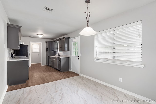 202 NE B St NE, Inola, OK 74036 - kitchen featuring light countertops, baseboards, marble look tile flooring, and freestanding refrigerator