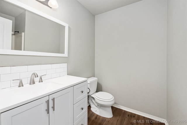 202 NE B St NE, Inola, OK 74036 - bathroom with toilet, wood finished floors, vanity, baseboards, and tasteful backsplash