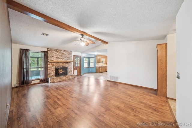 2910 S Main St, Sapulpa, OK 74066 - unfurnished living room with ceiling fan, a textured ceiling, wood finished floors, a fireplace, and baseboards