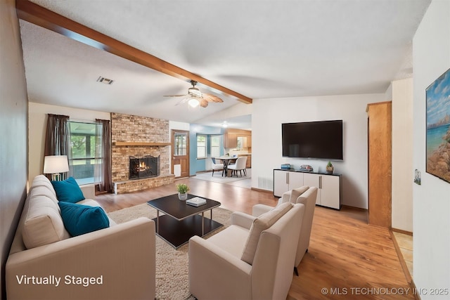 2910 S Main St, Sapulpa, OK 74066 - living room featuring light wood-style flooring, a brick fireplace, a ceiling fan, and baseboards
