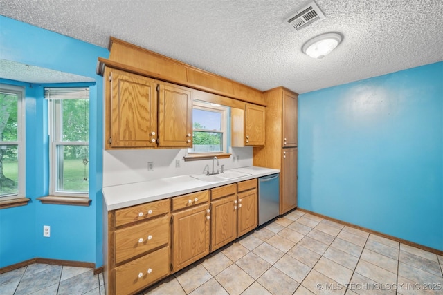 2910 S Main St, Sapulpa, OK 74066 - kitchen featuring stainless steel dishwasher, a sink, a textured ceiling, light countertops, and brown cabinetry