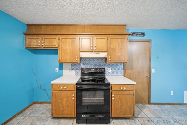 2910 S Main St, Sapulpa, OK 74066 - kitchen with electric range, under cabinet range hood, light countertops, a textured ceiling, and baseboards
