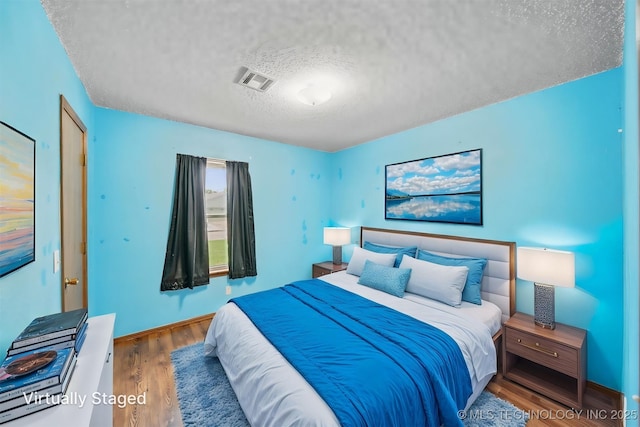 2910 S Main St, Sapulpa, OK 74066 - bedroom featuring a textured ceiling and wood finished floors