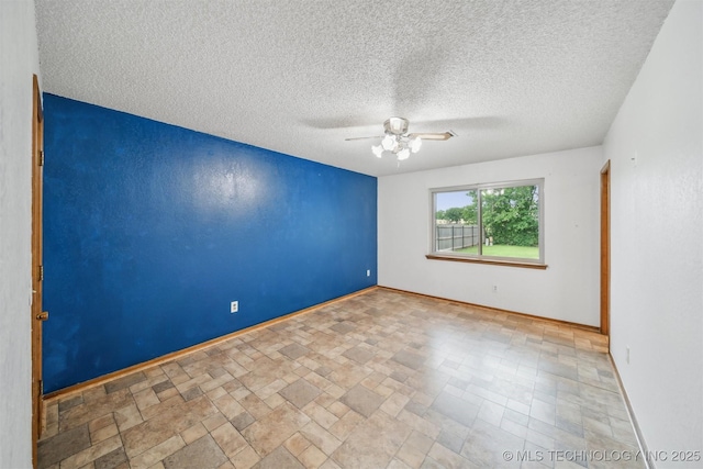 2910 S Main St, Sapulpa, OK 74066 - empty room with a ceiling fan, baseboards, a textured ceiling, and stone finish floors