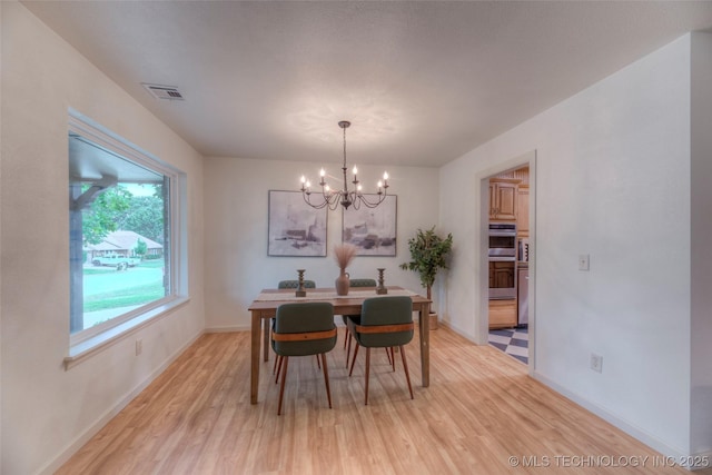 8221 S 74th E Ave, Tulsa, OK 74133 - dining space featuring a chandelier, light wood-style floors, and baseboards