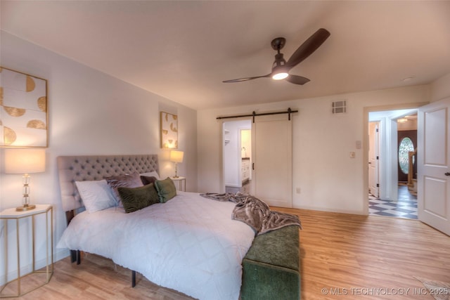 8221 S 74th E Ave, Tulsa, OK 74133 - bedroom featuring a barn door, wood finished floors, and ceiling fan