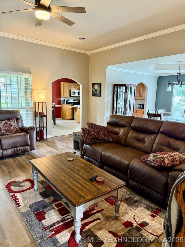9701 N 98th E Ave, Owasso, OK 74055 - living area featuring arched walkways, light wood-type flooring, crown molding, ceiling fan, and a chandelier