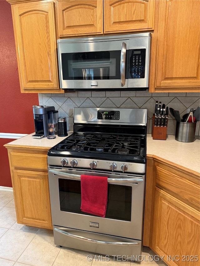 9701 N 98th E Ave, Owasso, OK 74055 - kitchen with stainless steel appliances, light countertops, tasteful backsplash, and light tile patterned floors