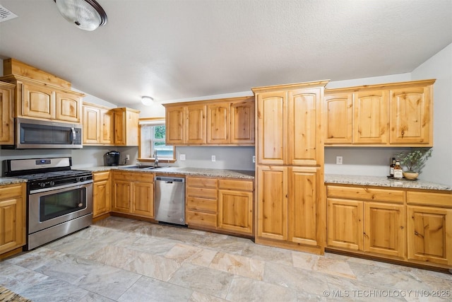 6529 S 159th Ave W, Sapulpa, OK 74066 - kitchen featuring stainless steel appliances, a sink, light stone finish floors, light stone countertops, and lofted ceiling