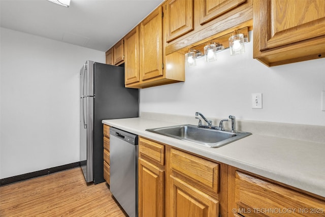 410 W 7th St Unit 1122, Tulsa, OK 74119 - kitchen featuring dishwasher, a sink, light countertops, light wood finished floors, and brown cabinetry
