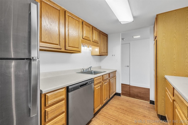 410 W 7th St Unit 1122, Tulsa, OK 74119 - kitchen with appliances with stainless steel finishes, a sink, light wood-type flooring, and light countertops