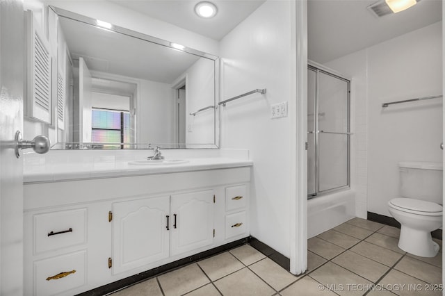 410 W 7th St Unit 1122, Tulsa, OK 74119 - full bath featuring vanity, tile patterned flooring, toilet, bath / shower combo with glass door, and baseboards