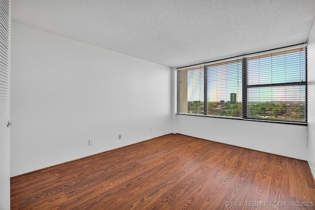 410 W 7th St Unit 1122, Tulsa, OK 74119 - spare room featuring a textured ceiling and wood finished floors