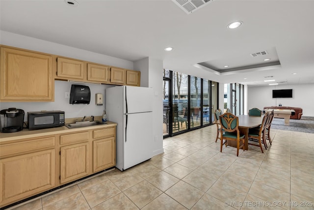 410 W 7th St Unit 1122, Tulsa, OK 74119 - kitchen with black microwave, freestanding refrigerator, light brown cabinetry, recessed lighting, and light tile patterned flooring