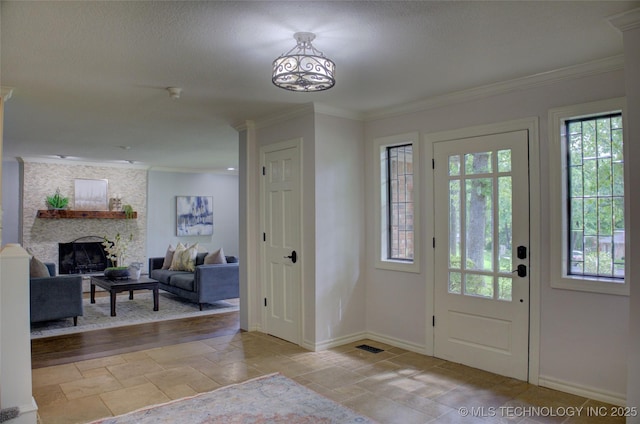 10520 S 69th E Ave, Tulsa, OK 74133 - entrance foyer featuring baseboards, crown molding, a stone fireplace, and a textured ceiling
