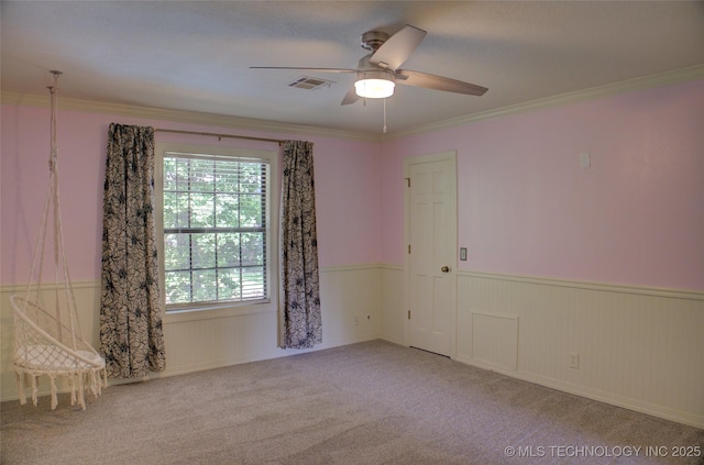 10520 S 69th E Ave, Tulsa, OK 74133 - spare room featuring a wainscoted wall, a ceiling fan, carpet floors, and crown molding