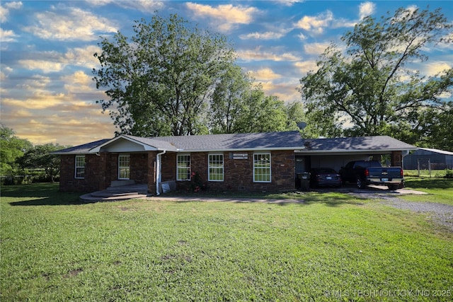 8845 Chestnut Rd, Henryetta, OK 74437 - ranch-style house with stone siding, a carport, a front lawn, and driveway