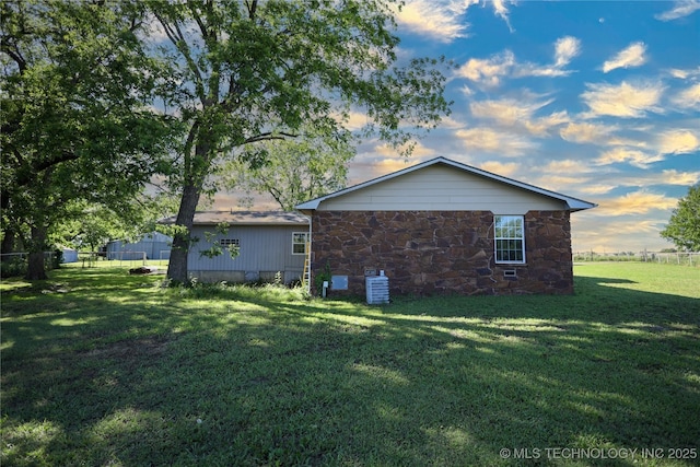 8845 Chestnut Rd, Henryetta, OK 74437 - view of property exterior featuring stone siding and central AC