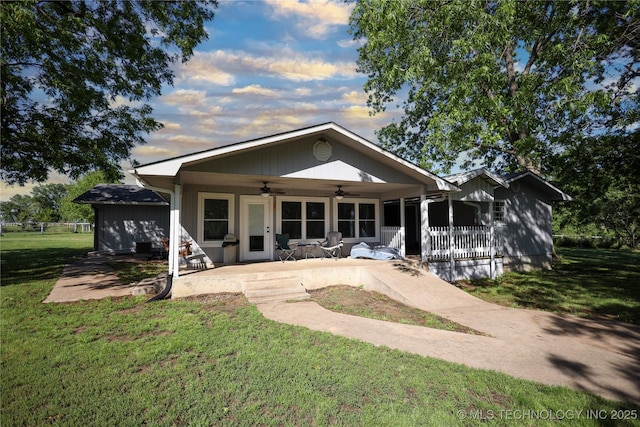 8845 Chestnut Rd, Henryetta, OK 74437 - back of property at dusk featuring ceiling fan, a yard, and a porch