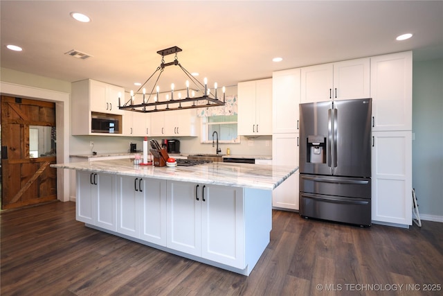 8845 Chestnut Rd, Henryetta, OK 74437 - kitchen with appliances with stainless steel finishes, dark wood finished floors, white cabinetry, light stone counters, and recessed lighting