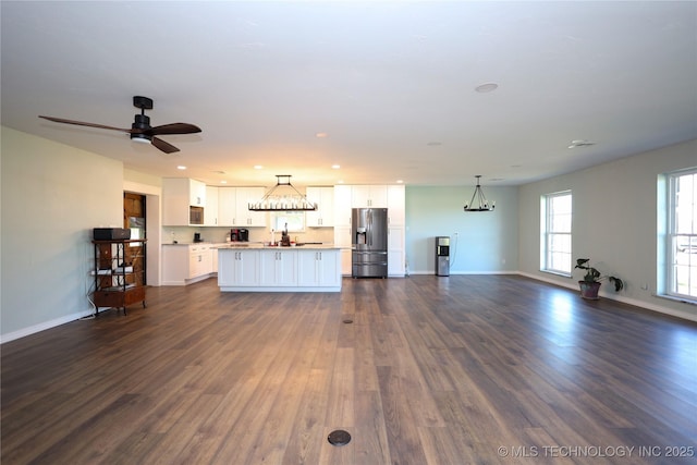 8845 Chestnut Rd, Henryetta, OK 74437 - unfurnished living room with dark wood-style flooring, baseboards, ceiling fan, a chandelier, and recessed lighting
