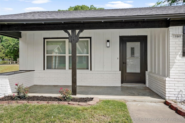 11607 E 24th St, Tulsa, OK 74129 - entrance to property featuring brick siding, a shingled roof, and a porch