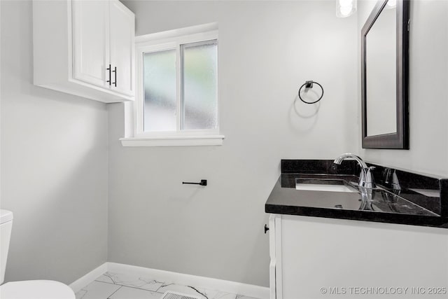 11607 E 24th St, Tulsa, OK 74129 - bathroom with toilet, baseboards, marble look tiles, and vanity