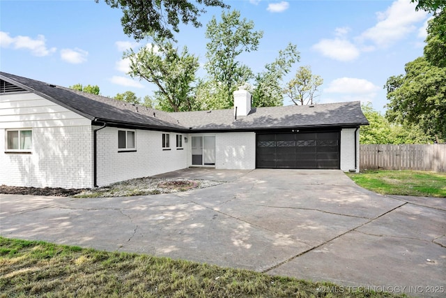 11607 E 24th St, Tulsa, OK 74129 - view of front facade featuring a garage, brick siding, a chimney, and concrete driveway