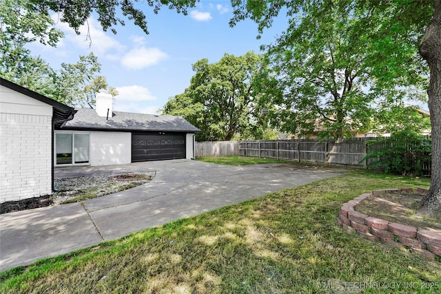 11607 E 24th St, Tulsa, OK 74129 - view of yard featuring driveway and a garage