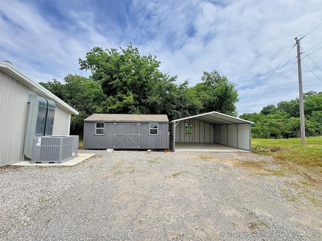 15588 N Sunset Valley Rd, Hulbert, OK 74441 - garage with central air condition unit, a carport, a storage shed, and dirt driveway